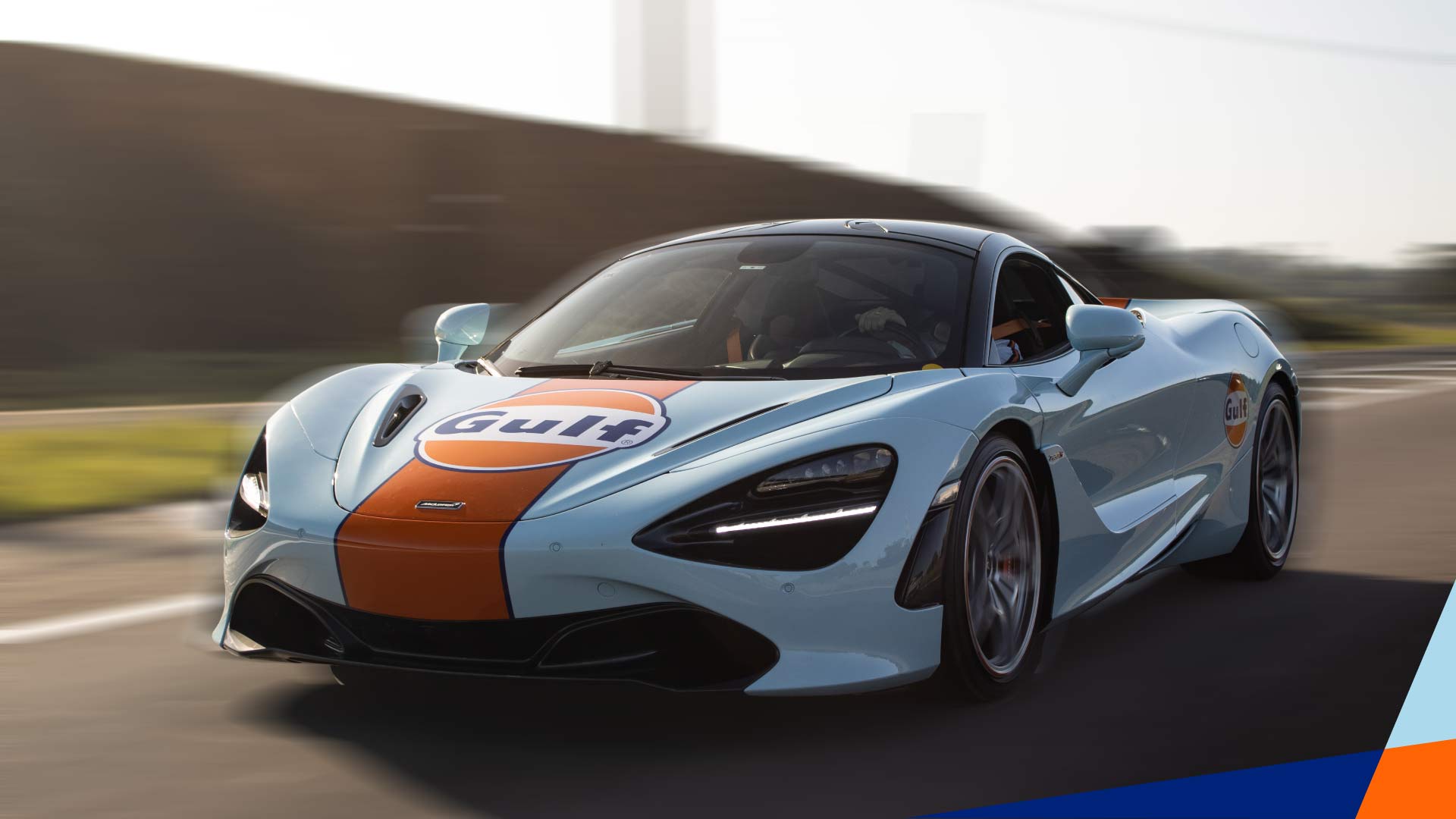 Gasolina super aditivada da Gulf em um carro esportivo com as cores da Gulf em alta velocidade, com fundo borrado.